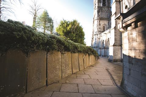 Tombstones form the boundary to a path around the side of the cathedral. The site has housed a church since AD 606.