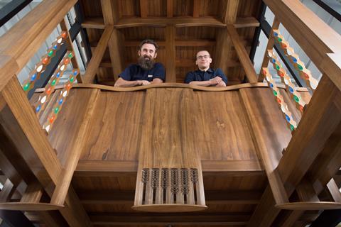 A picture taken between the two fires of master craftsmen Angus Johnston and Martins Cirulis of Laurence McIntosh in the prototype of a Mackintosh library bay they created